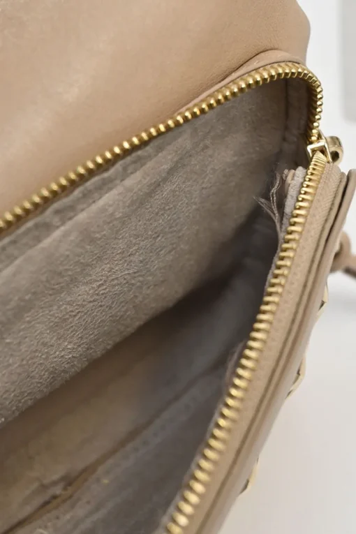 Beige studded leather convertible backpack with zip straps