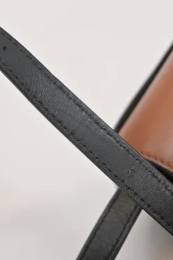 Black and brown leather Heel Duo anagram-embossed shoulder flap bag with adjustable shoulder strap
