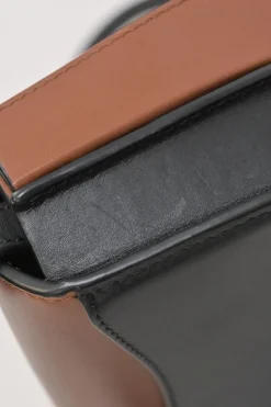 Black and brown leather Heel Duo anagram-embossed shoulder flap bag with adjustable shoulder strap