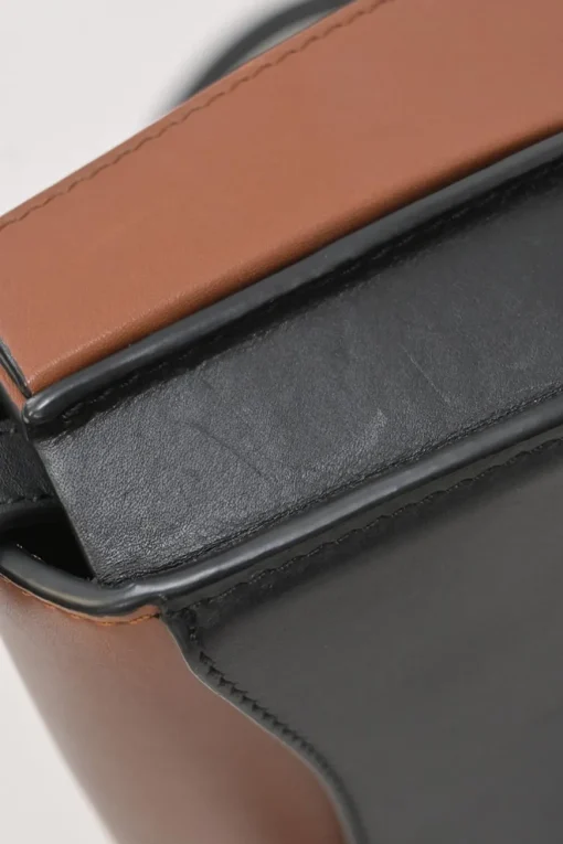 Black and brown leather Heel Duo anagram-embossed shoulder flap bag with adjustable shoulder strap