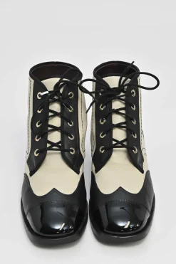Black and ivory two-tone leather lace-up ankle boots with with patent cap toes