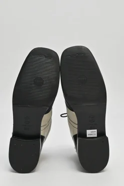 Black and ivory two-tone leather lace-up ankle boots with with patent cap toes