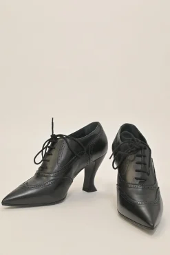 Black brogued leather pointed-toe lace-up Victorian-style heeled booties with metallic Coco Mark heel plaque appliqué