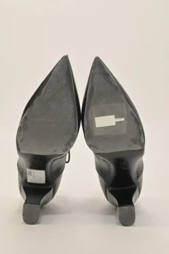 Black brogued leather pointed-toe lace-up Victorian-style heeled booties with metallic Coco Mark heel plaque appliqué