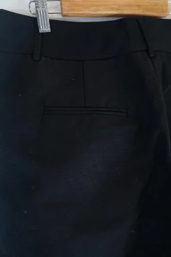 Black cotton low-rise flared tailored trousers with concealed bar and zip closure at front
