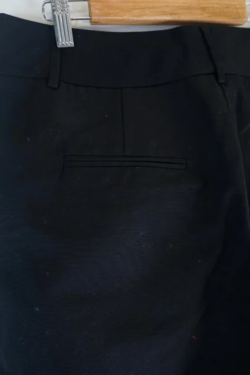 Black cotton low-rise flared tailored trousers with concealed bar and zip closure at front