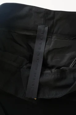 Black cotton low-rise flared tailored trousers with concealed bar and zip closure at front