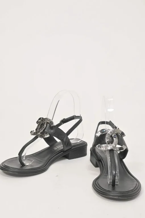 Black leather slingback thong sandals featuring cabochon Coco Mark logo plaque