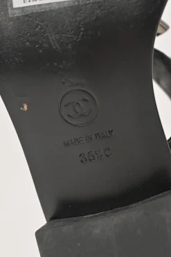 Black leather slingback thong sandals featuring cabochon Coco Mark logo plaque