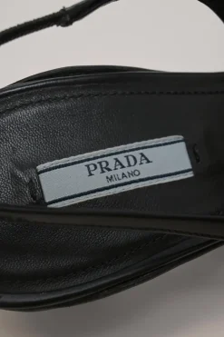 Black mesh, leather and rubber pointed-toe slingback kitten-heel pumps with metallic enamel logo vamp plaque