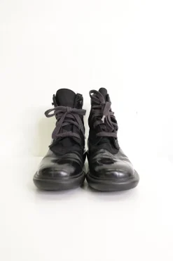 Black paneled fabric and leather lace-up mid-calf boots with rubber soles and webbing details