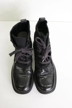 Black paneled fabric and leather lace-up mid-calf boots with rubber soles and webbing details