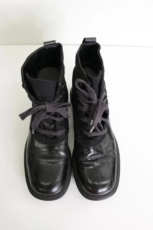 Black paneled fabric and leather lace-up mid-calf boots with rubber soles and webbing details