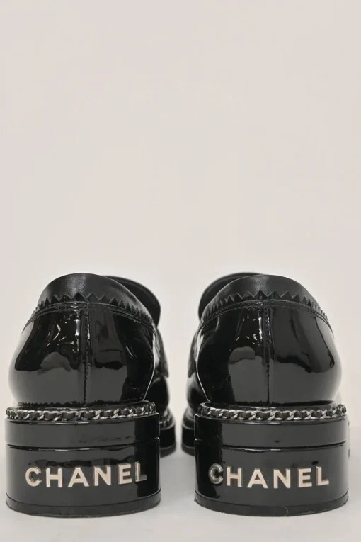 Black patent leather and calfskin round-toe penny-style pinked edge loafers with chainlink vamp appliqué