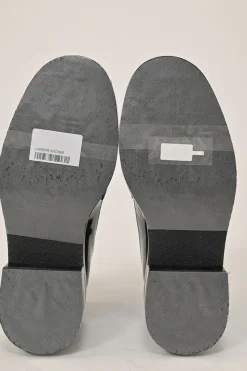 Black patent leather and calfskin round-toe penny-style pinked edge loafers with chainlink vamp appliqué