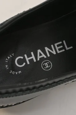 Black patent leather and calfskin round-toe penny-style pinked edge loafers with chainlink vamp appliqué