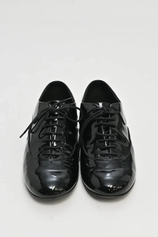 Black patent leather lace-up brogues with gold-tone metallic Coco Mark ankle and heel plaque