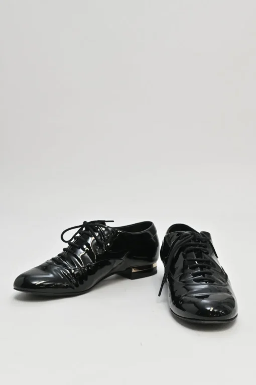 Black patent leather lace-up brogues with gold-tone metallic Coco Mark ankle and heel plaque