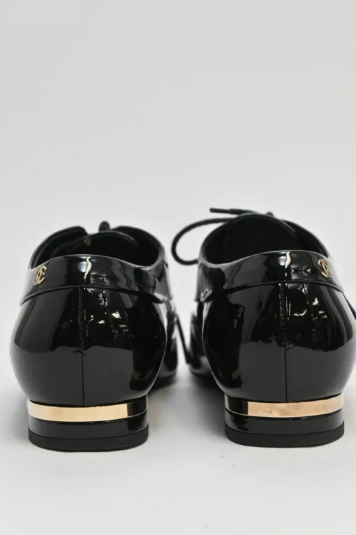 Black patent leather lace-up brogues with gold-tone metallic Coco Mark ankle and heel plaque
