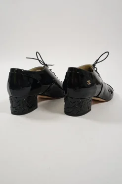 Black patent leather lace-up brogues with Coco Mark ankle plaque and sculpted camellia block heel