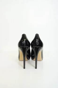 Black patent platform pumps with grosgrain Vara bow wrapped in brand's signature engraved metal plaque