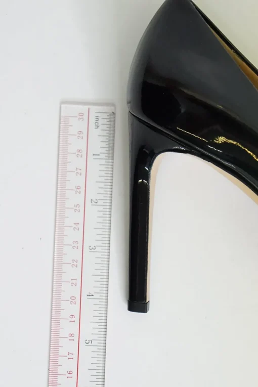 Black patent platform pumps with grosgrain Vara bow wrapped in brand's signature engraved metal plaque