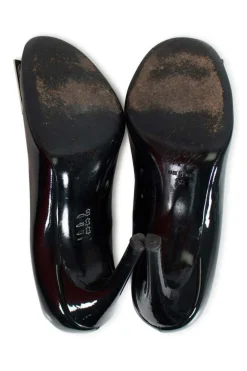 Black patent round toe pump with silver-tone signature square buckle