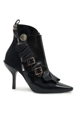 Black polished calfskin and leather pointed toe monk strap-style zip-up ankle booties with ruffle trim