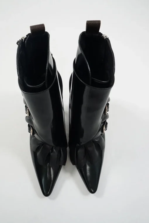 Black polished calfskin and leather pointed toe monk strap-style zip-up ankle booties with ruffle trim