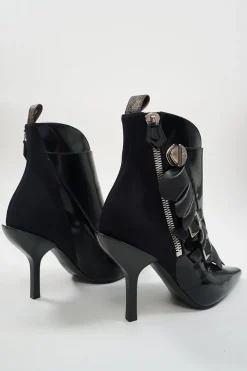 Black polished calfskin and leather pointed toe monk strap-style zip-up ankle booties with ruffle trim