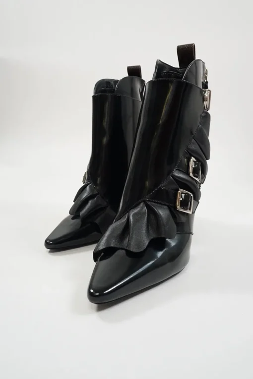 Black polished calfskin and leather pointed toe monk strap-style zip-up ankle booties with ruffle trim