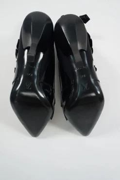 Black polished calfskin and leather pointed toe monk strap-style zip-up ankle booties with ruffle trim
