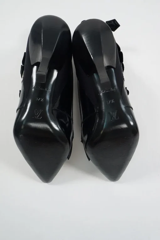 Black polished calfskin and leather pointed toe monk strap-style zip-up ankle booties with ruffle trim