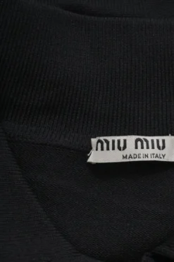 Black polyamide piqué half-button spread collar polo top featuring logo initial chest logo patch