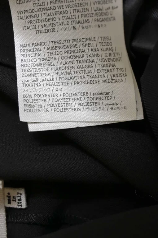 Black polyester-blend high-rise tapered leg tailored trousers with raw-edge hem and contrasting topstitching details