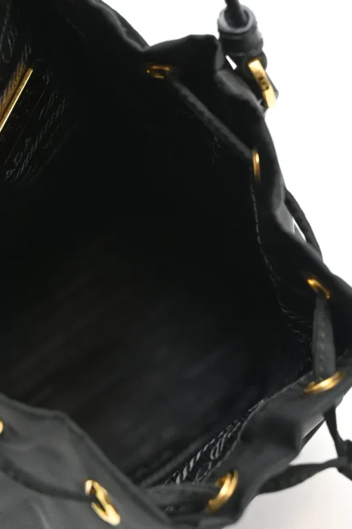Black re-nylon duet drawstring bucket bag with front zip pocket in gold-tone metallic hardware
