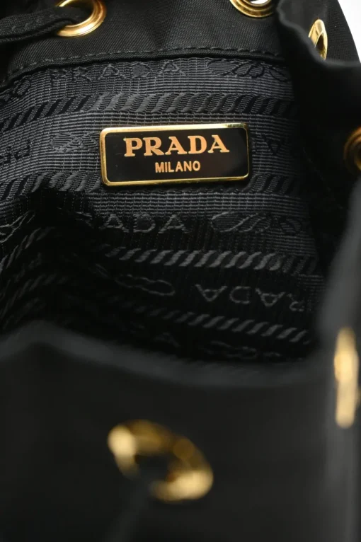 Black re-nylon duet drawstring bucket bag with front zip pocket in gold-tone metallic hardware