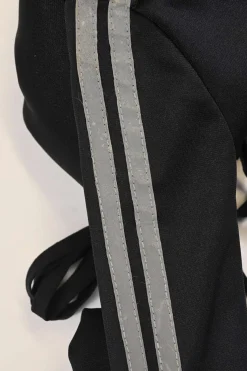 Black stretch-nylon corset style two-piece tracksuit featuring full-zip jacket and high-waist pants with side stripe and lace-up detailing