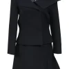 Black wool-silk blend two-piece skirt suit featuring asymmetric spread collar tailored jacket and drop-waist flounce mini skirt