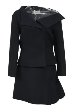 Black wool-silk blend two-piece skirt suit featuring asymmetric spread collar tailored jacket and drop-waist flounce mini skirt