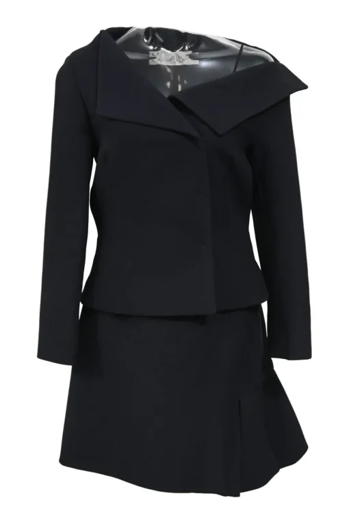 Black wool-silk blend two-piece skirt suit featuring asymmetric spread collar tailored jacket and drop-waist flounce mini skirt