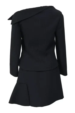 Black wool-silk blend two-piece skirt suit featuring asymmetric spread collar tailored jacket and drop-waist flounce mini skirt