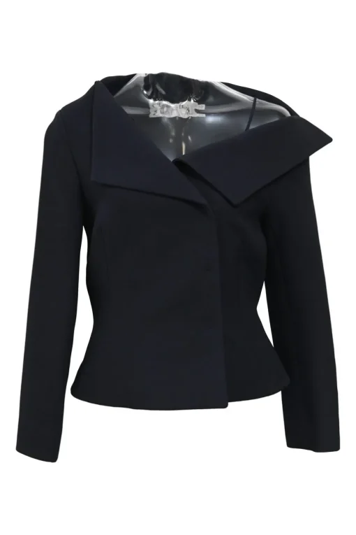 Black wool-silk blend two-piece skirt suit featuring asymmetric spread collar tailored jacket and drop-waist flounce mini skirt