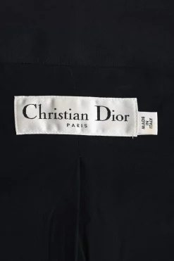 Black wool-silk blend two-piece skirt suit featuring asymmetric spread collar tailored jacket and drop-waist flounce mini skirt