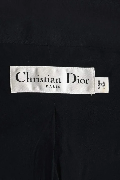 Black wool-silk blend two-piece skirt suit featuring asymmetric spread collar tailored jacket and drop-waist flounce mini skirt