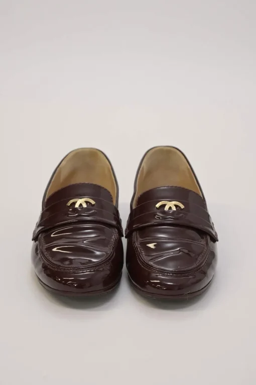 Brown patent leather round-toe slip-on penny loafers with gold-tone metallic Coco Mark vamp appliqué