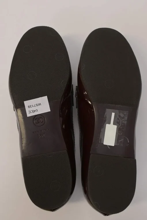 Brown patent leather round-toe slip-on penny loafers with gold-tone metallic Coco Mark vamp appliqué