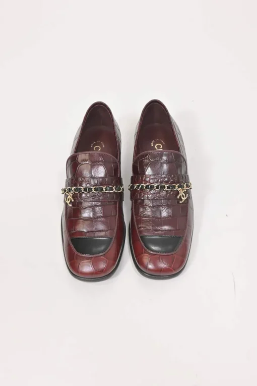 Burgundy croc-embossed leather slip-on loafers featuring chainlink Coco Mark charm vamp appliqué