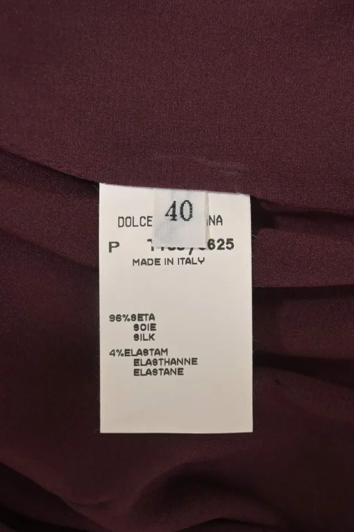 Burgundy two-piece skirt suit featuring sleeveless blouse and midi pencil skirt