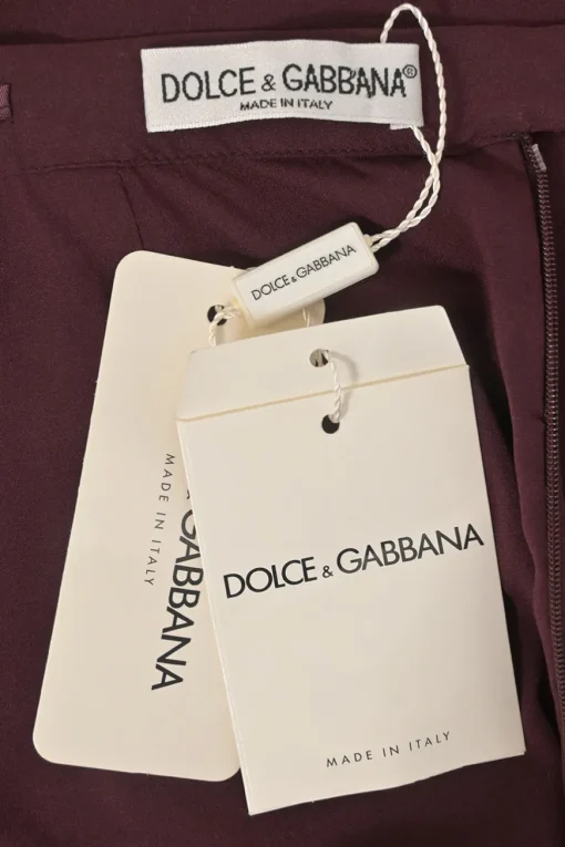 Burgundy two-piece skirt suit featuring sleeveless blouse and midi pencil skirt